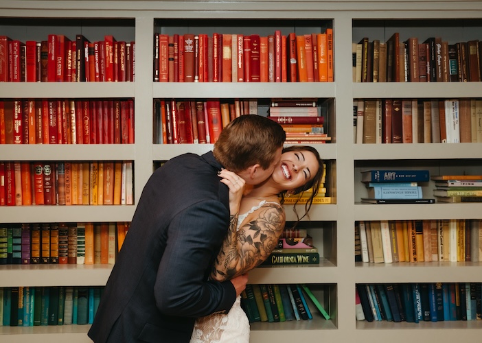 A couple kisses indoors during an intimate elopement ceremony