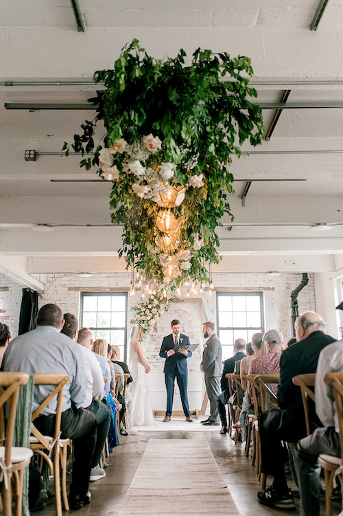 Wedding aisle with a floral chandelier suspended overhead at a small wedding venue near Philadelphia