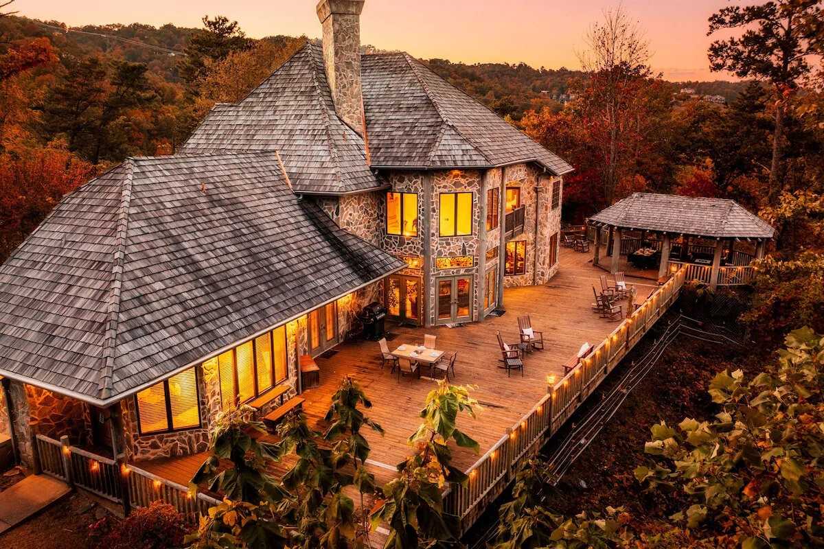 Mountain Bliss Estate luxury cabin with large wooden deck and sunset mountain views