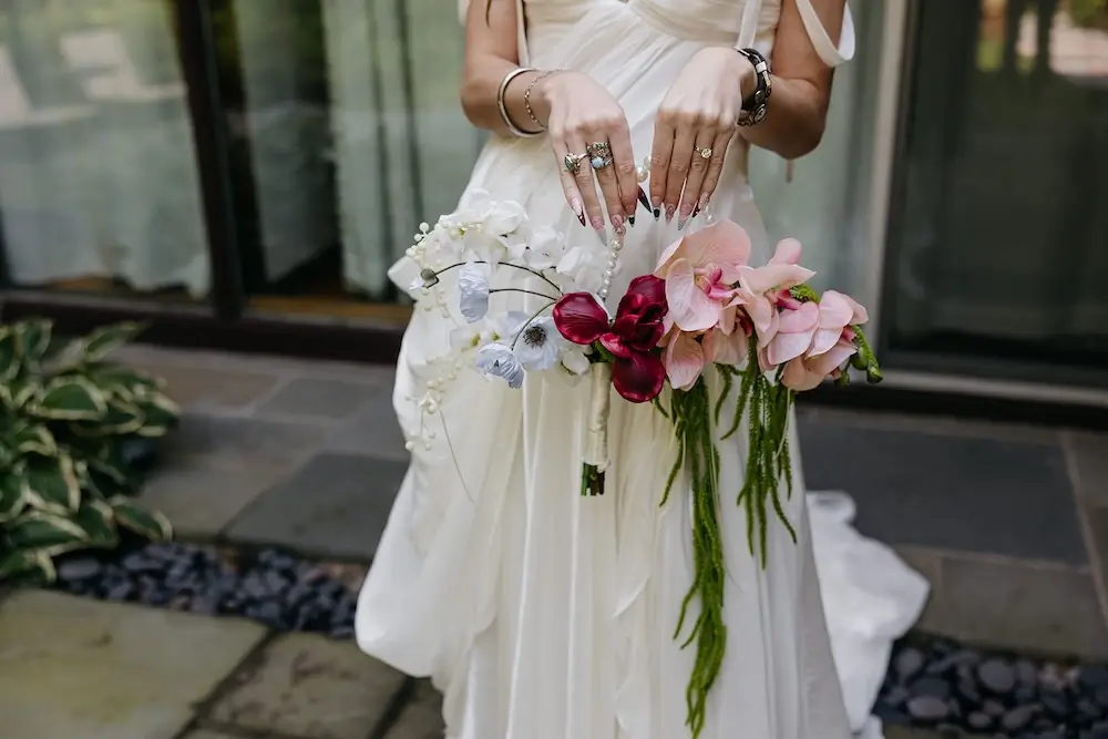 modern asymmetrical wedding bouquet with orchids anthurium, cascading greenery and pearl detailing.