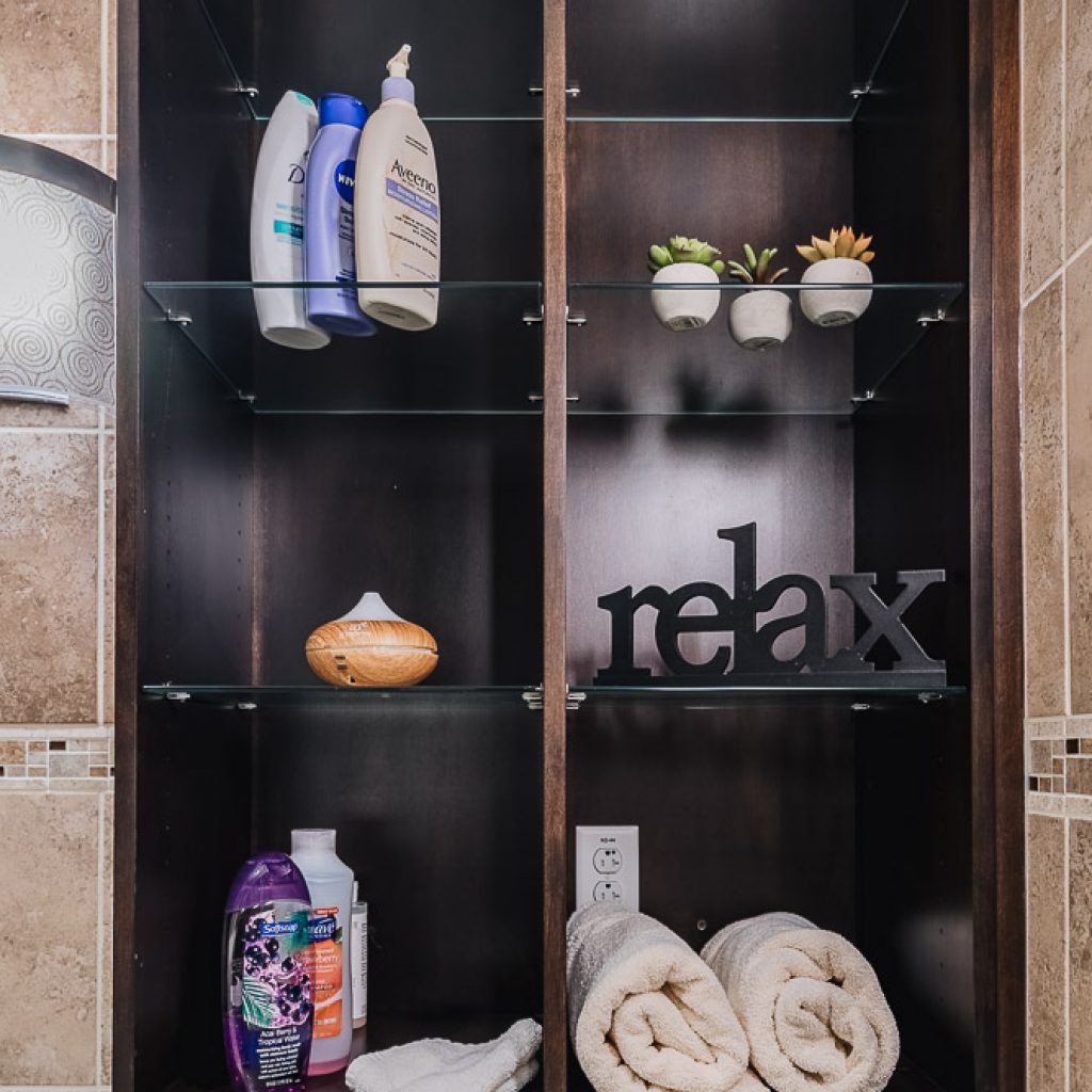 Shelves of towels, moisturizers, a diffuser, and more.