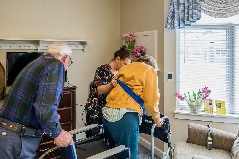 A physical therapist assisting two elders.