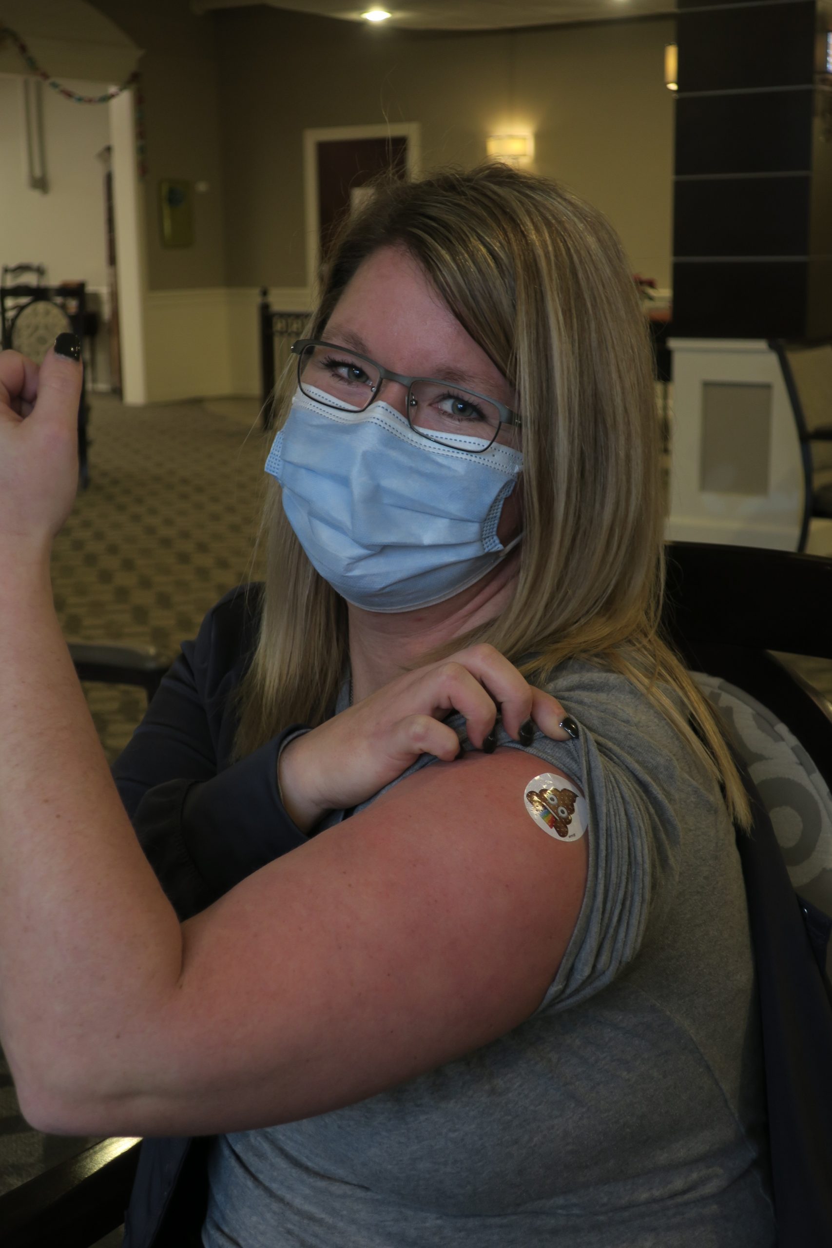 A band-aid on a woman's vaccination spot.