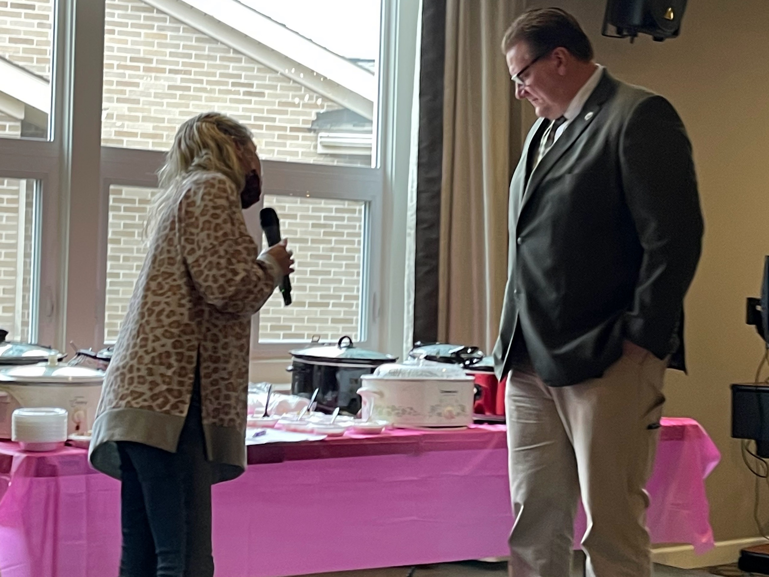 A woman on a small stage stands beside Mayor Matt Star.