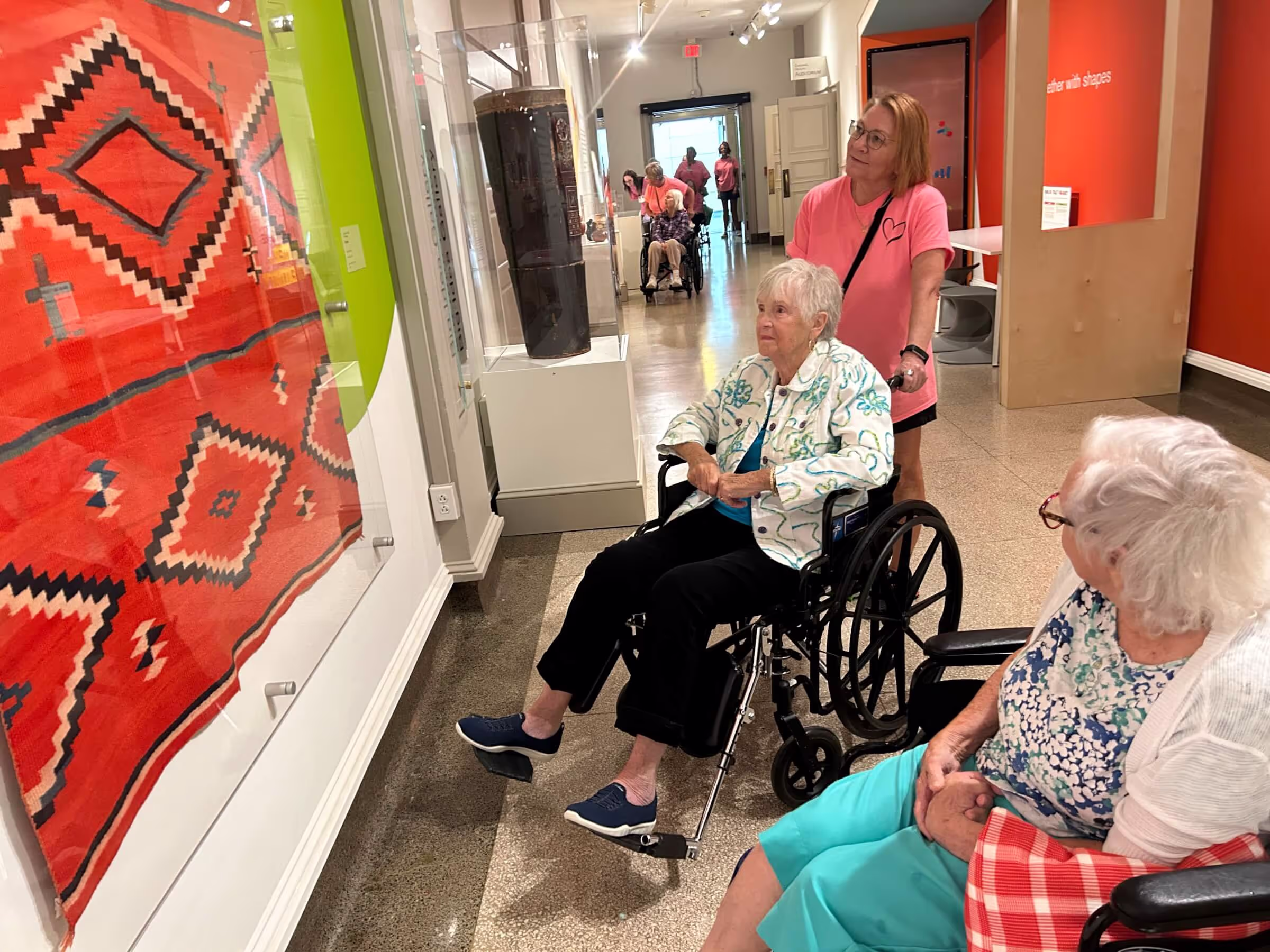 OESH staff and residents looking at art on a field trip for senior wellness. 