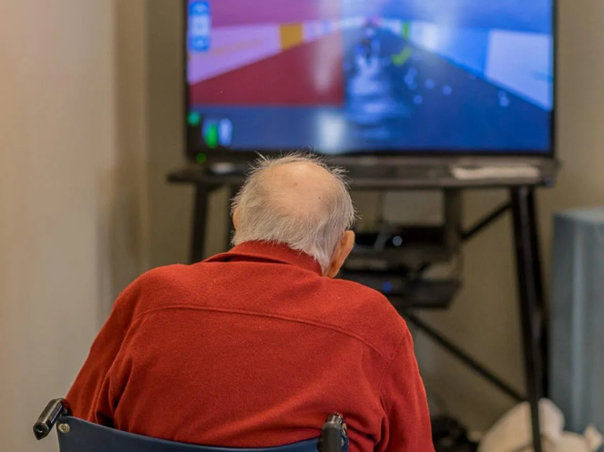 An elderly gentleman receiving rehabilitative services in the form of a session with a Jintronix VR machine.