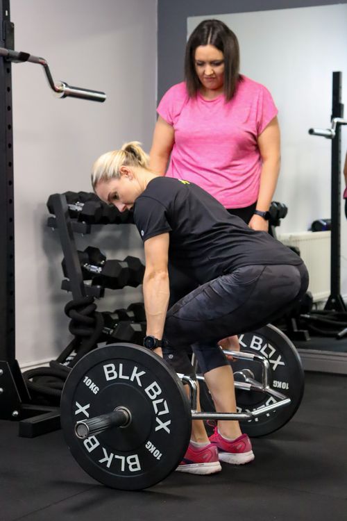 Nicole showing a client the correct form for a strength movement