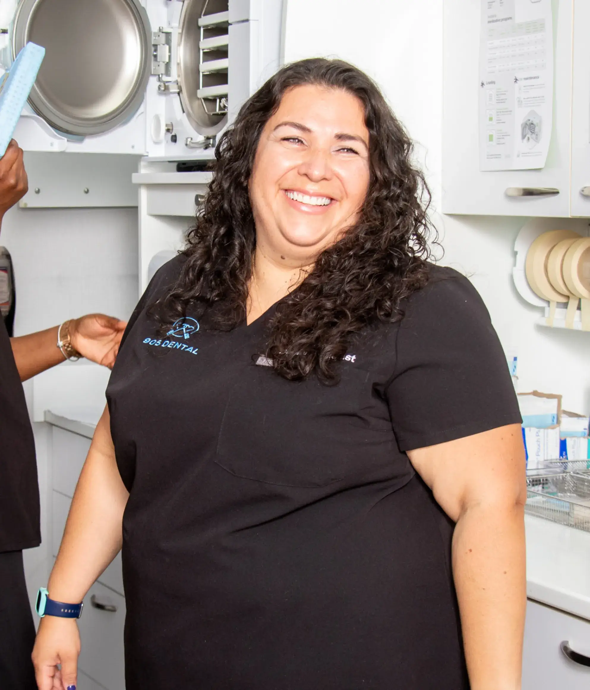 a woman in a black shirt standing in a kitchen