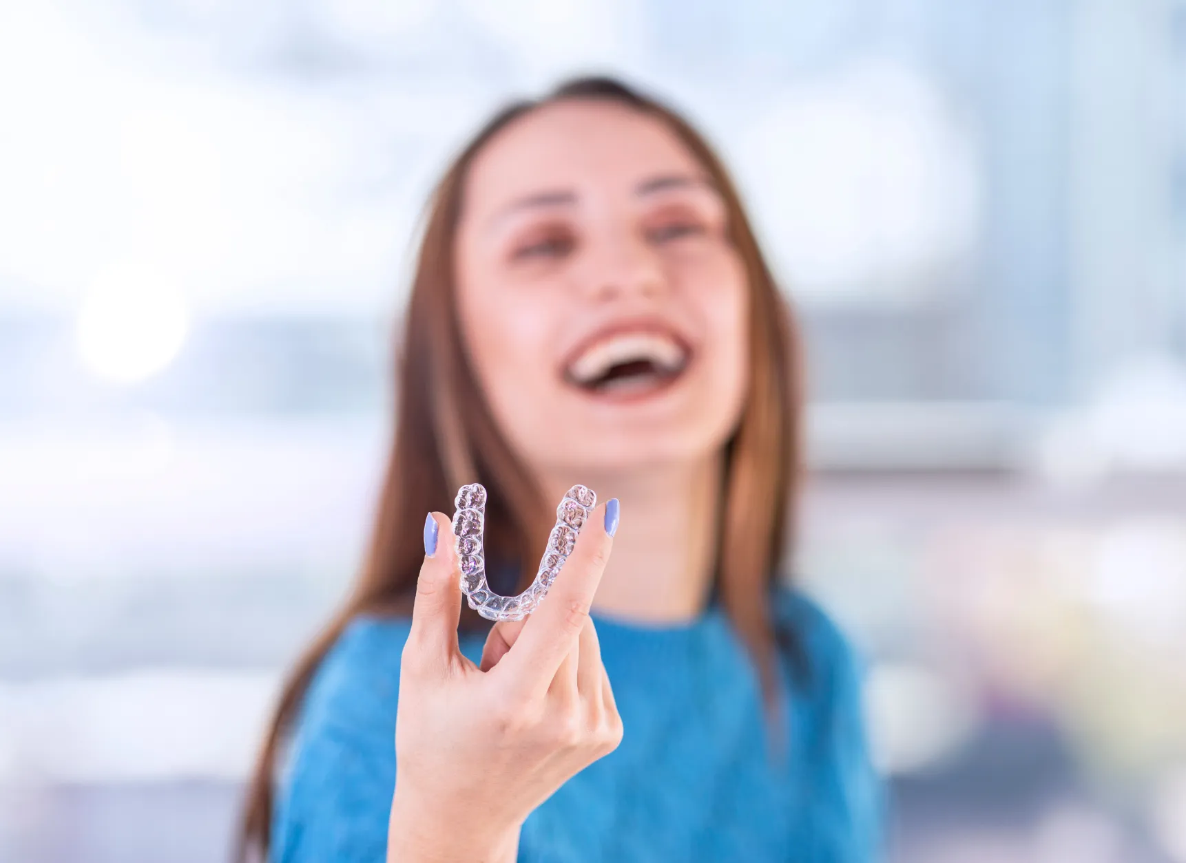 a woman holding up a toothbrush in front of her face