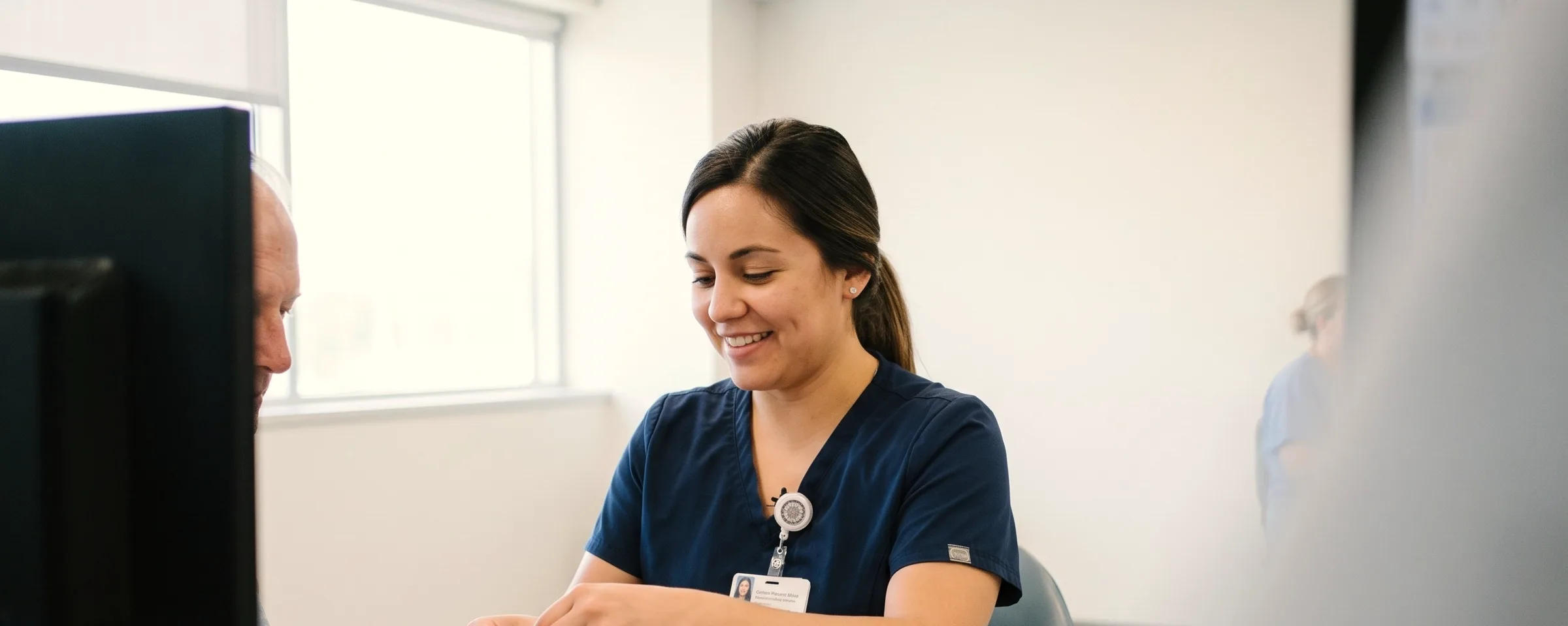 A nurse fits a printed wristband on a patient