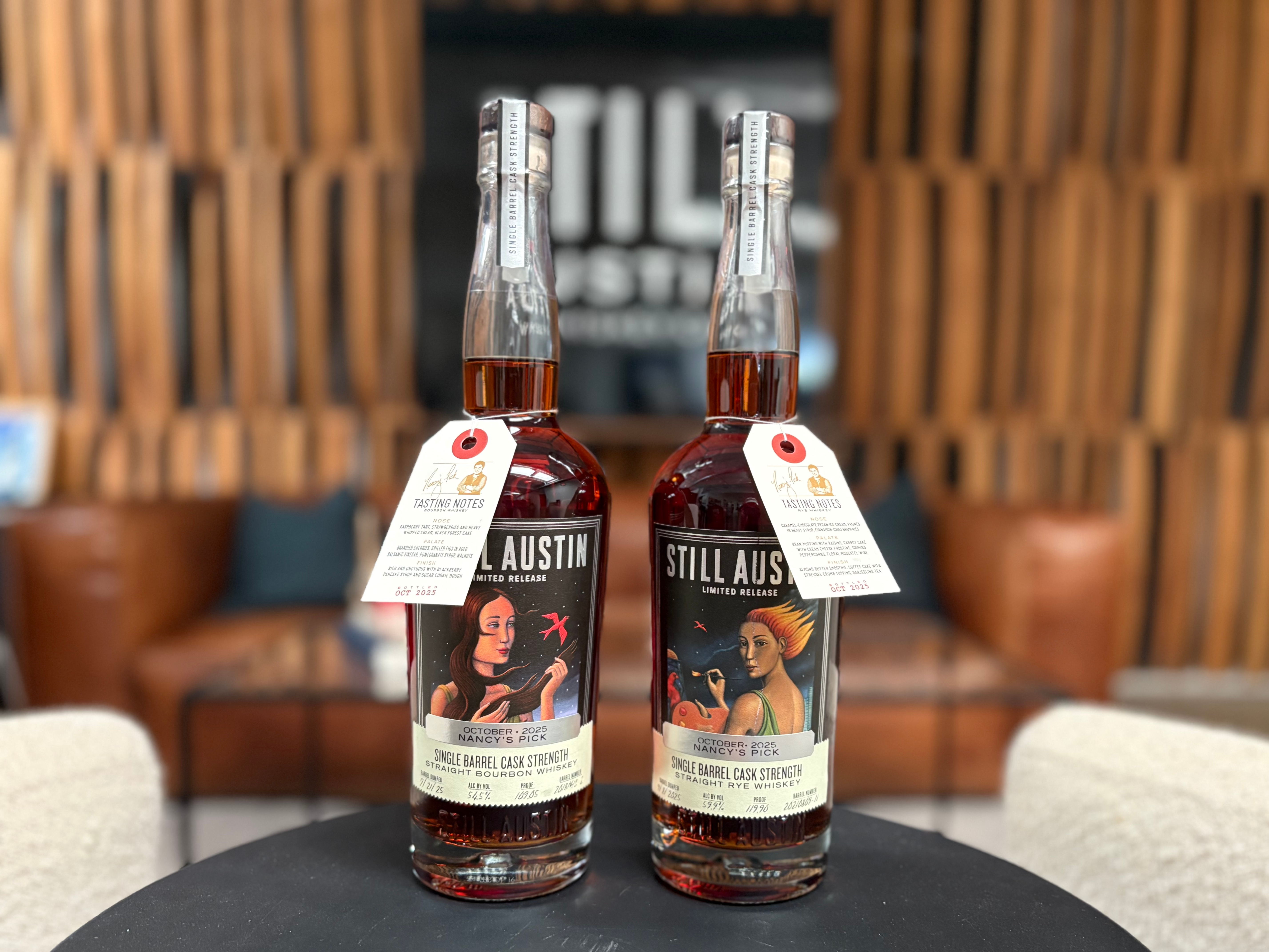 Two bottles of Still Austin Whiskey Co. October 2025 Nancy’s Pick Single Barrel Cask Strength releases —Straight Bourbon Whiskey and Straight Bourbon Rye— displayed in the distillery tasting room.