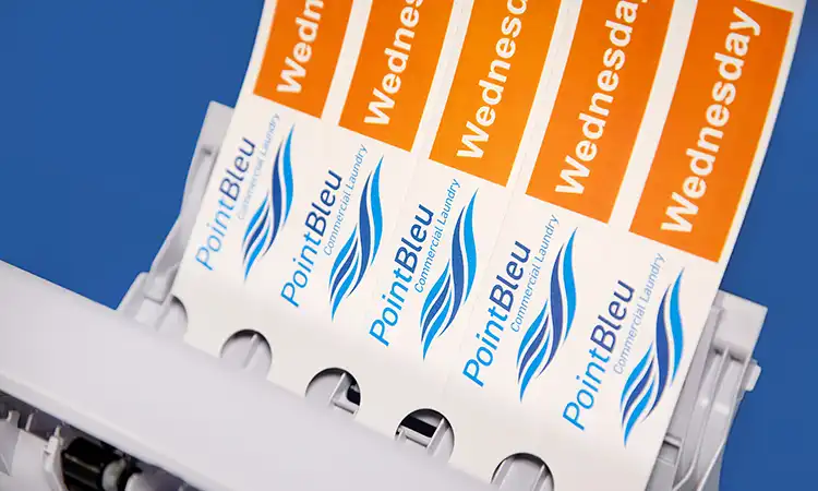Output tray of a laser printer showing full-colour printed self-tie loop lock labels