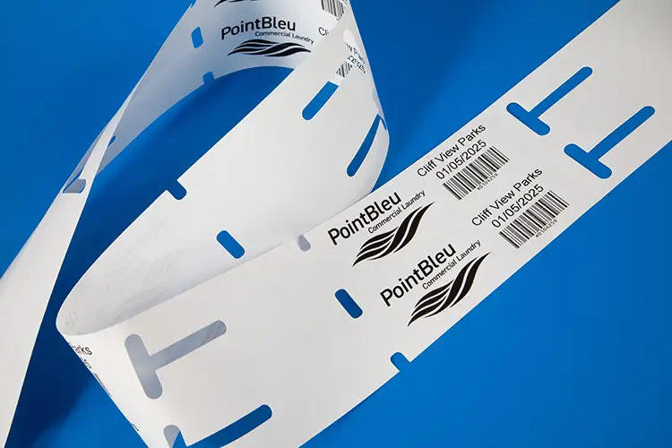 A thermal transfer printed self tie or loop lock label for the commercial laundry industry