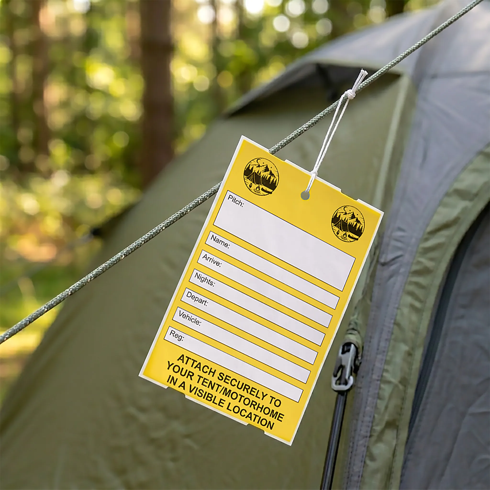  A tent tag on a tent guide rope at a woodland campsite, custom printed.