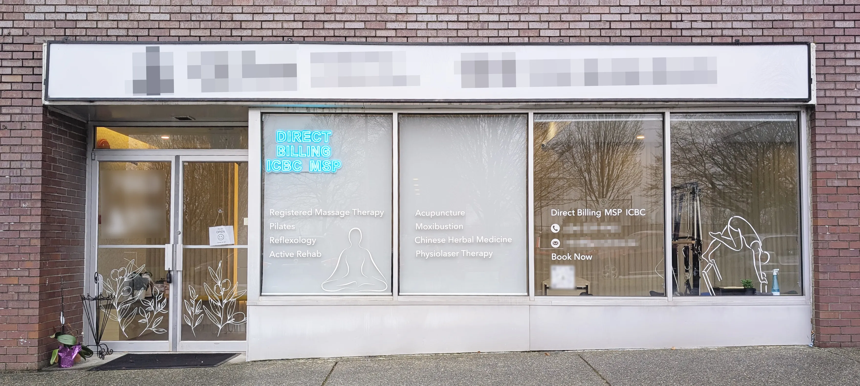 Exterior of a wellness clinic with glass windows listing services like massage therapy, Pilates, acupuncture, and Chinese herbal medicine, plus a neon sign for direct billing.