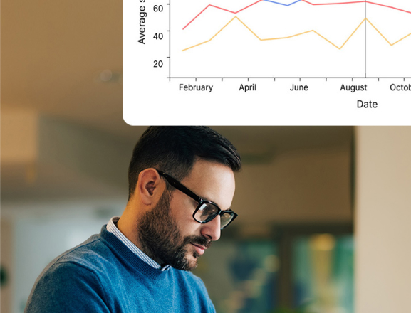 Man wearing glasses and a blue sweater, concentrating while working indoors.