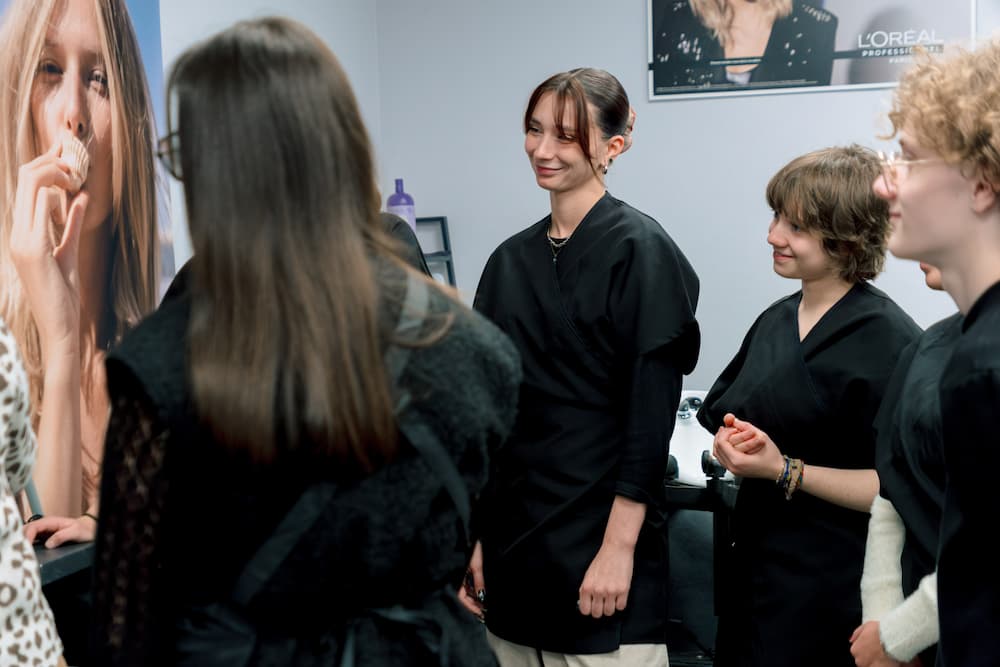 Elève en coiffure pendant un cas pratique au côté de Cyril Ronze