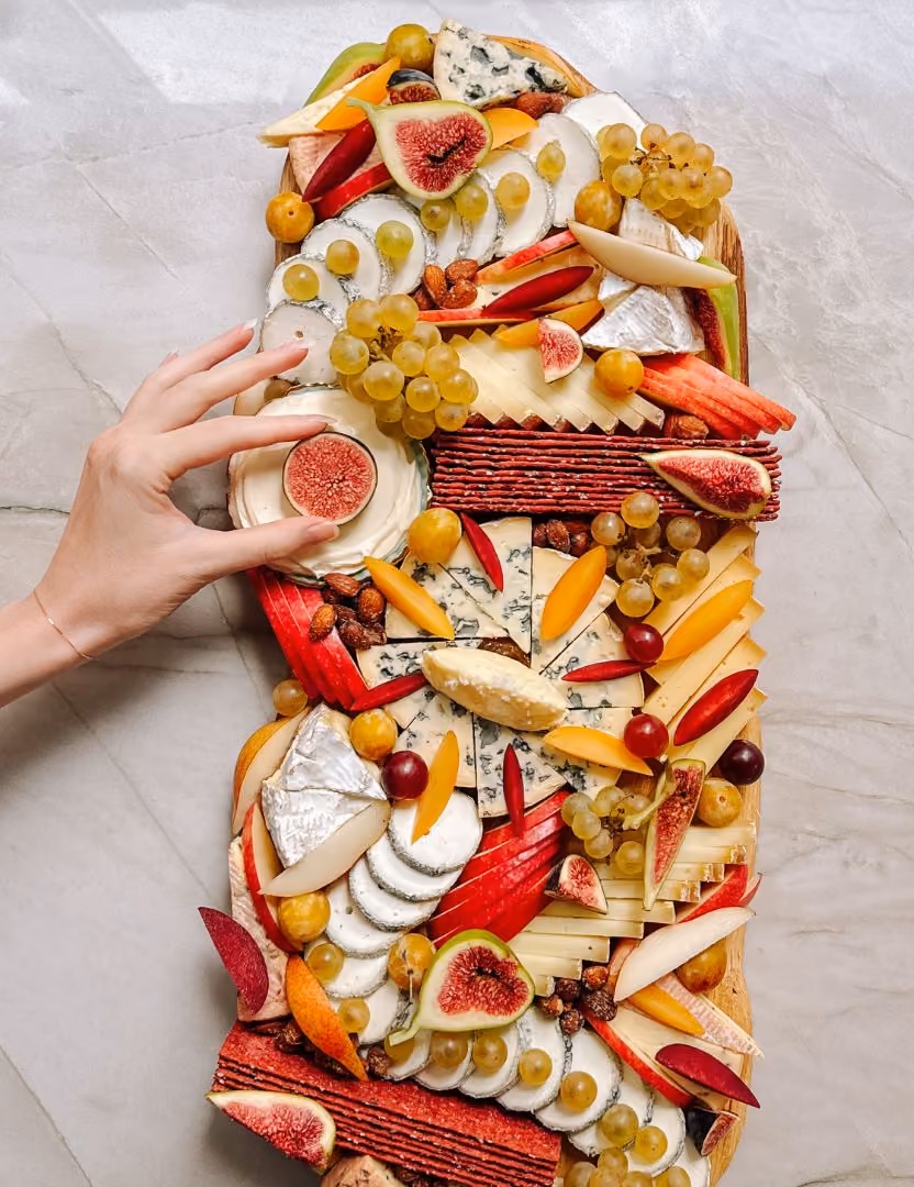 Plateau apéritif créatif et coloré composé de fruits, de fromages et de crackers