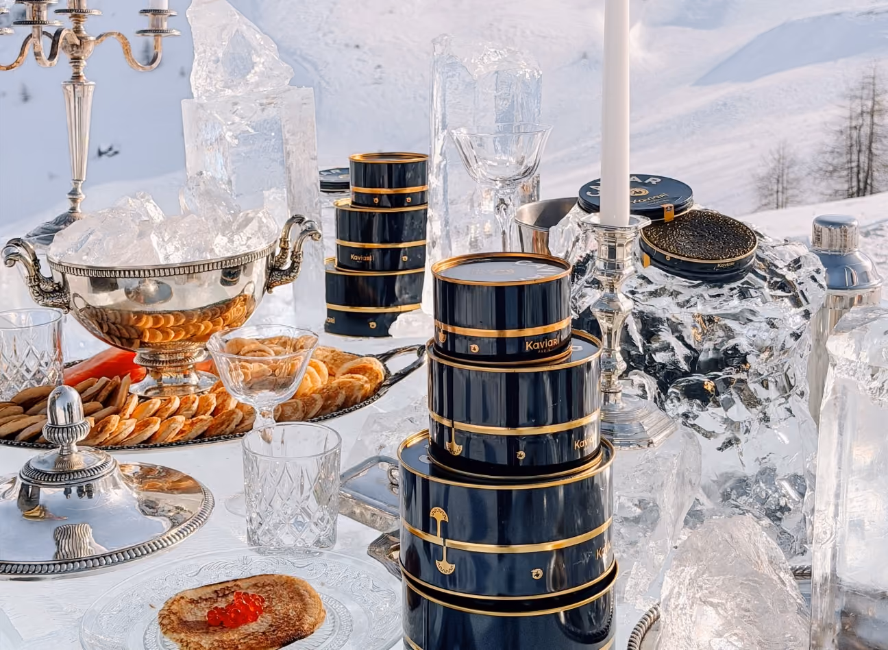 Scénographie Art de la table pour Kaviari sur une table de glace, avec argenterie et jeux de lumière dans un décor enneigé