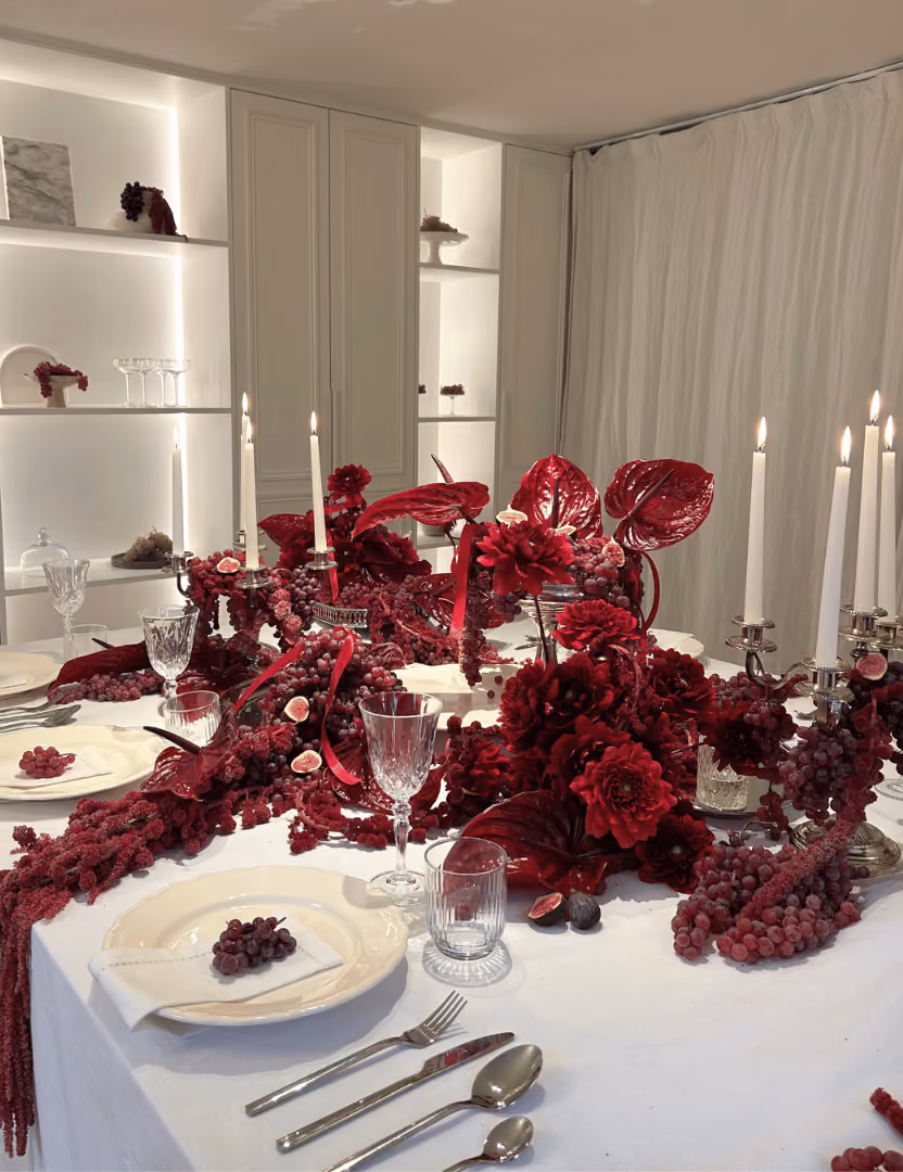 Art de la table sur le thème des vendanges, avec argenterie et profusion florale dans les tons bordeaux