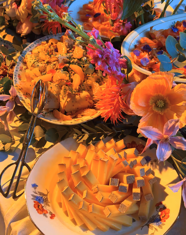 Focus sur les découpes de fromages et les détails du buffet de mariage à la scénographie florale colorée