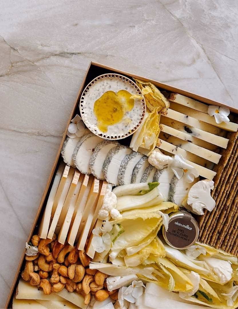 Plateau apéritif créatif composé de fromage, de dips, de crackers et de noix