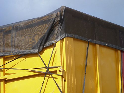 An close up from a container tailer with black mesh on top.