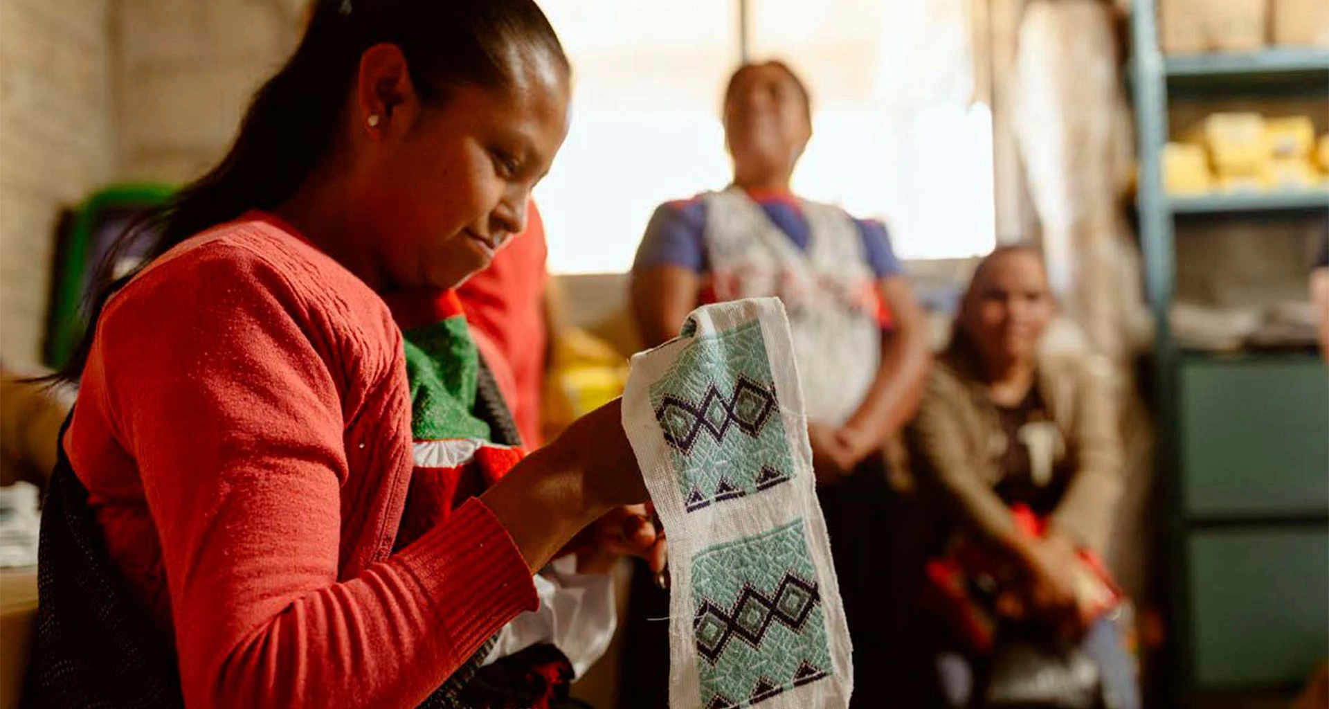 A woman working on embroidery in a Promotora Social México image.