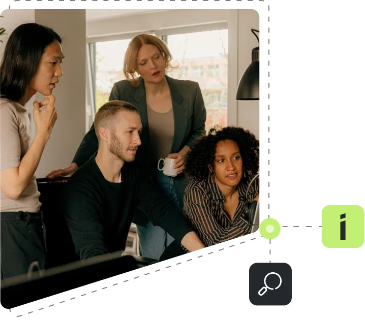 A group of people standing around a screen.