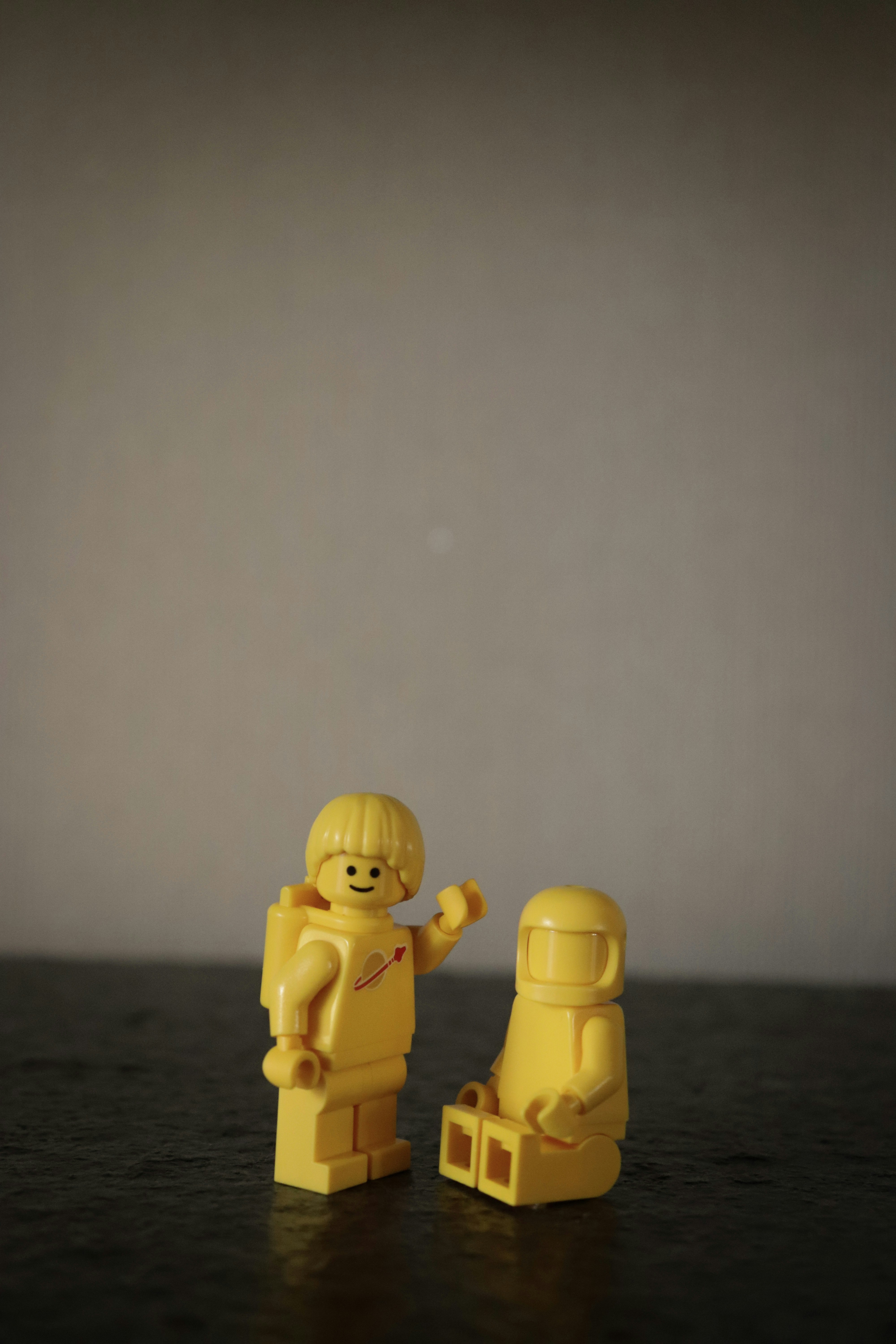 Two yellow lego minifigures on a table.