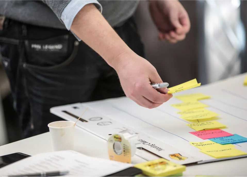 Man moving post-it notes on a board on a table