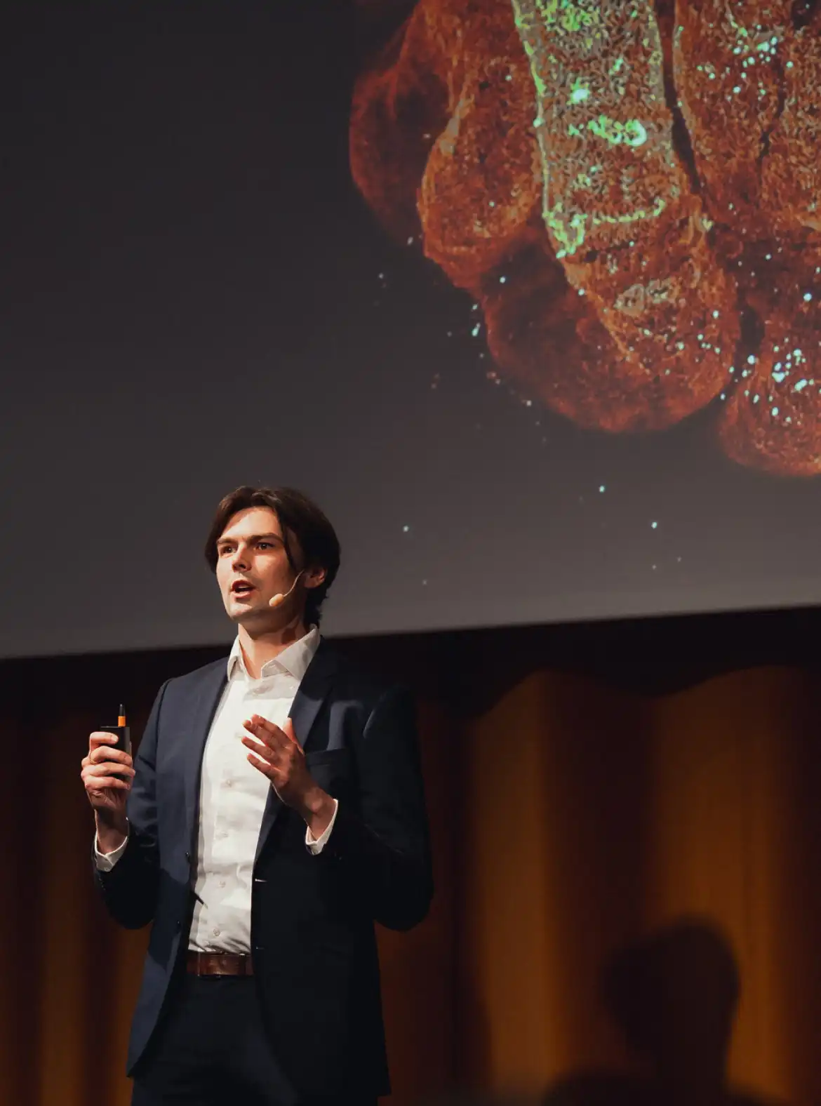 A man holding a presentation on a stage at Sting Demo Day