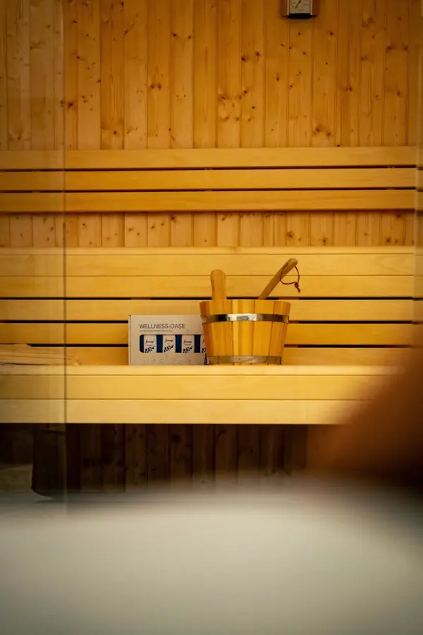 Private Sauna aus hellem Holz mit Aufgusskübel