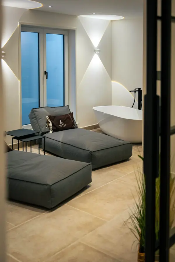 Badezimmer mit freistehender Badewanne und Loungemöbeln