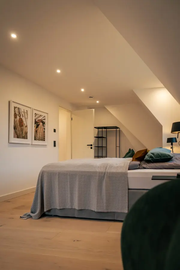 Schlafzimmer mit Doppelbett und gerahmten Bildern