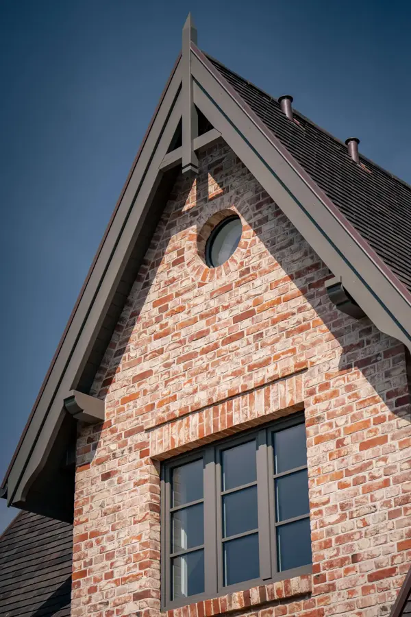 Giebeldetail mit rundem Fenster in der Backsteinfassade