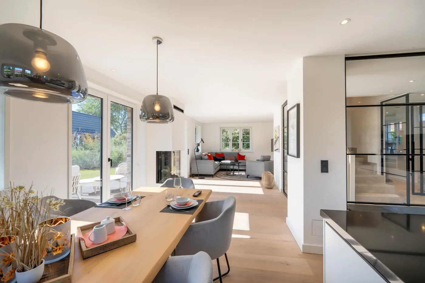 Offener Wohn- und Essbereich mit langem Holztisch und Blick bis zum Wohnzimmer