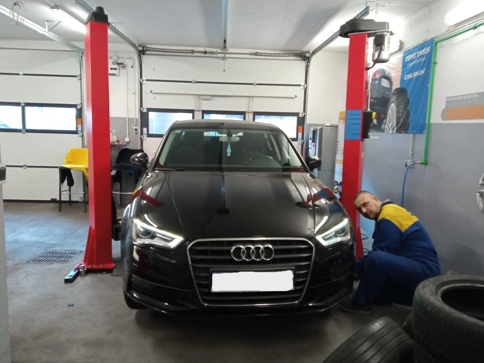 Majstor radi zamjenu guma na automobilu postavljenom na dizalicu – servis guma Zagreb.