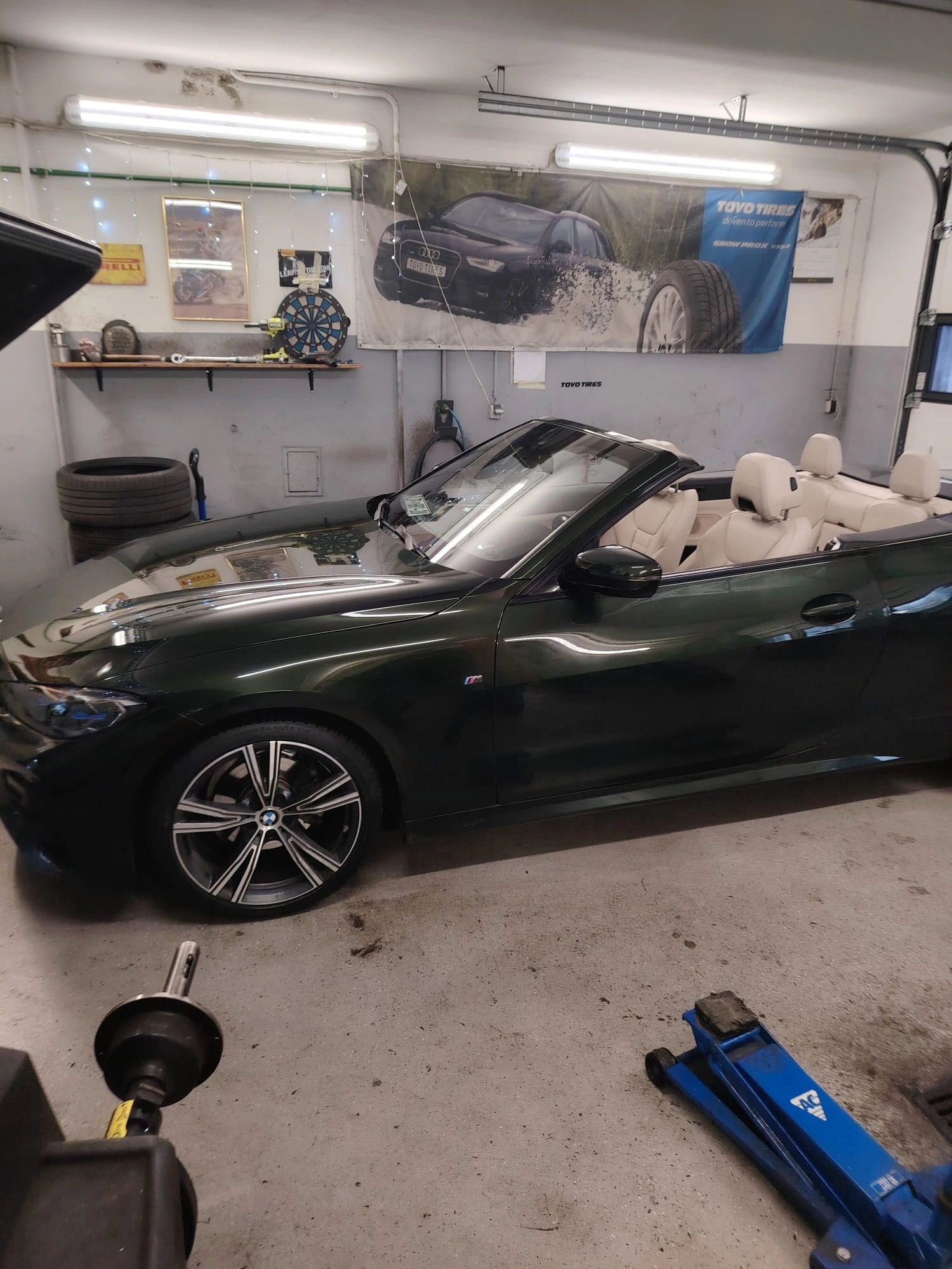 Bočni pogled na BMW Serije 4 tijekom zamjene guma u vulkanizerskoj radionici.