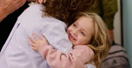 Emilia Aloni back from captivity, hugging a woman