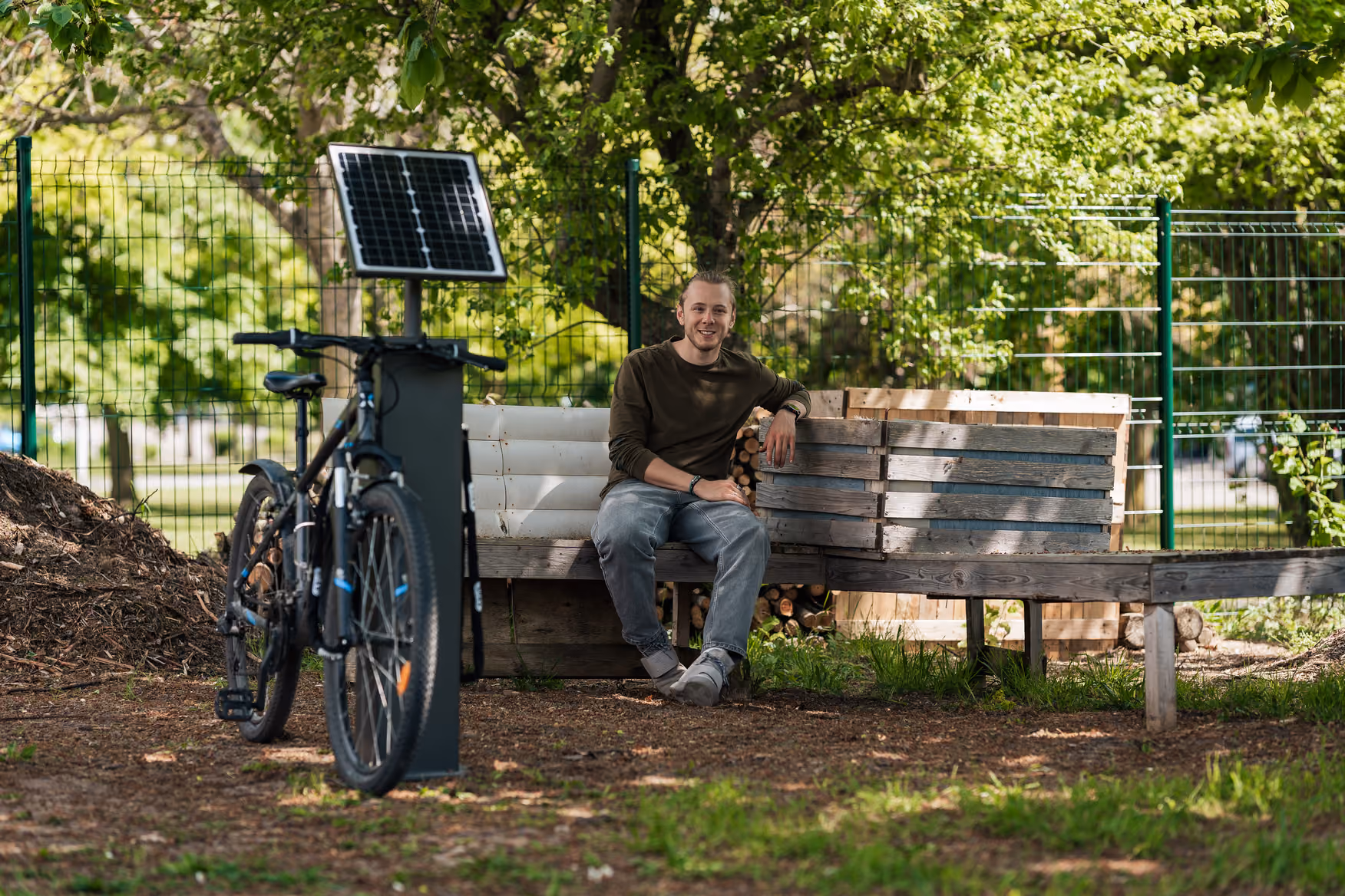 Antoine Desveronnieres, président et cofondateur de V-Lock, assis à côté d'une borne vélo V-Lock solaire