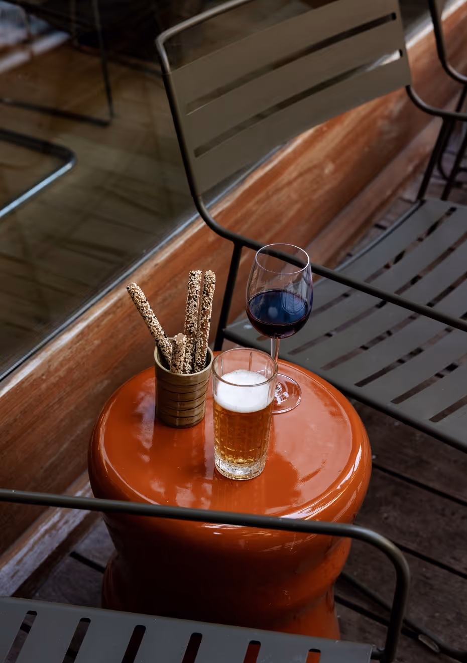 Biscuits apéritifs avec bière et verre de vin posé sur un tonneau Orso Hotels Paris