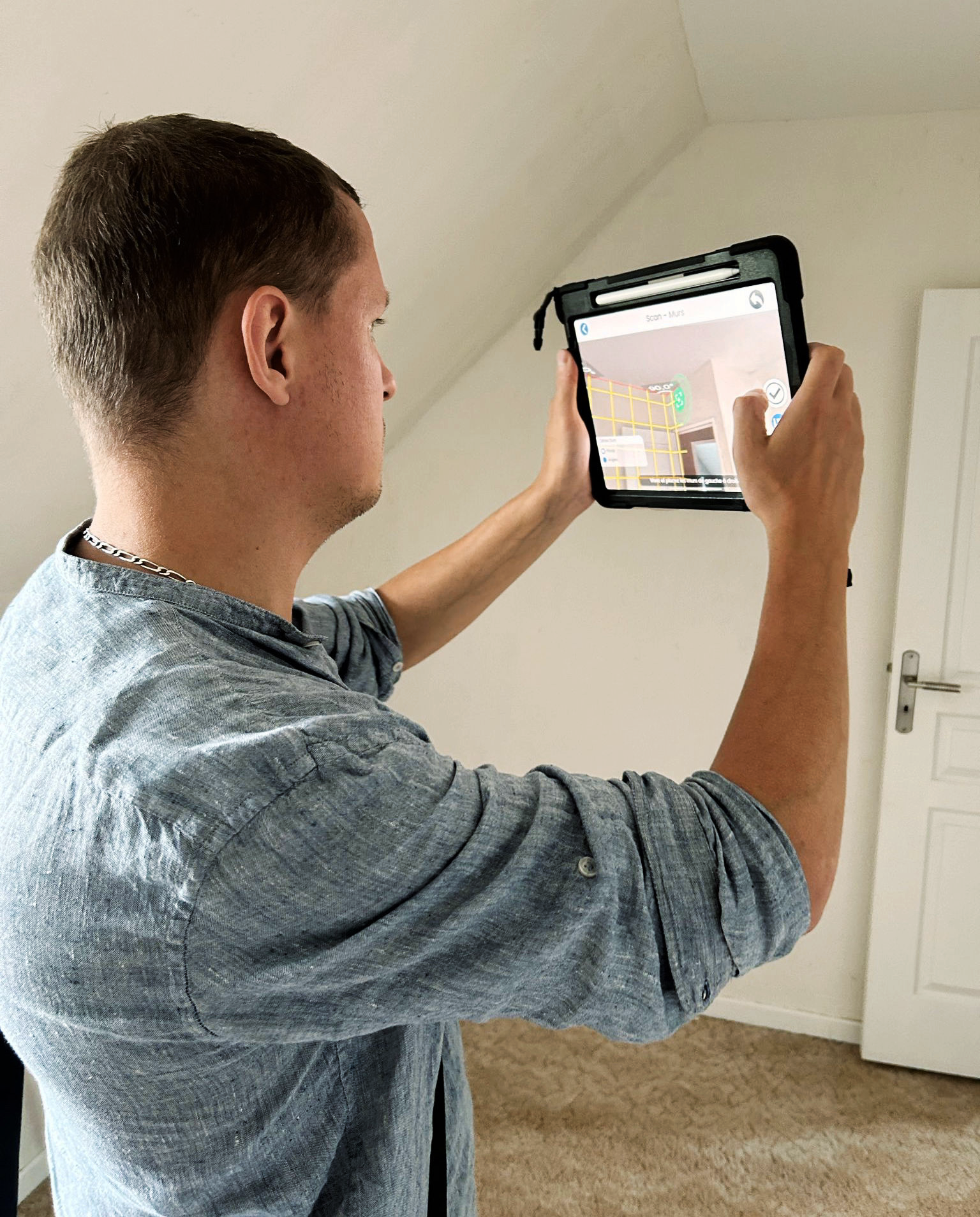 Thermicien de chez Aid'habitat qui réalise un audit énergétique à l'aide sa tablette