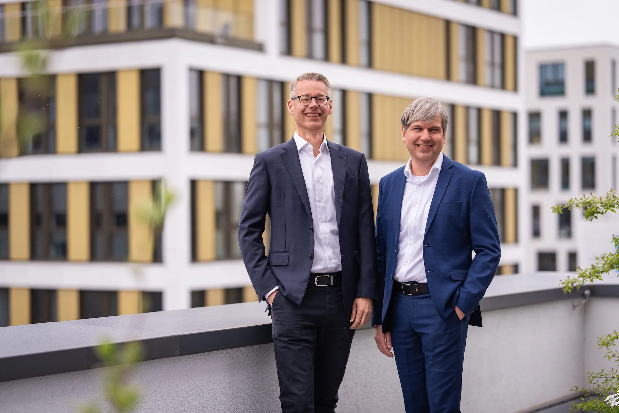 Two of the Adeleon team members in front of an office building