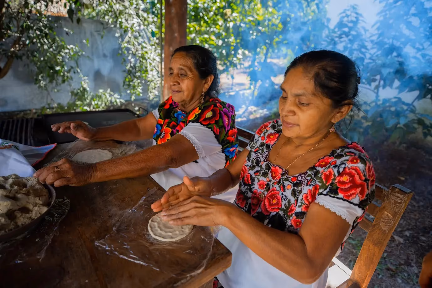 Dos mujeres de la comunidad haciendo tortillas