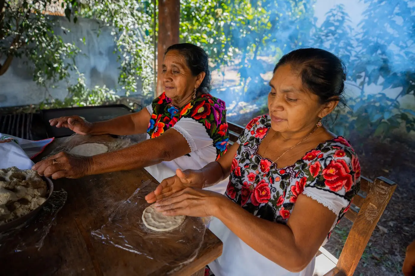 Dos mujeres de la comunidad haciendo tortillas