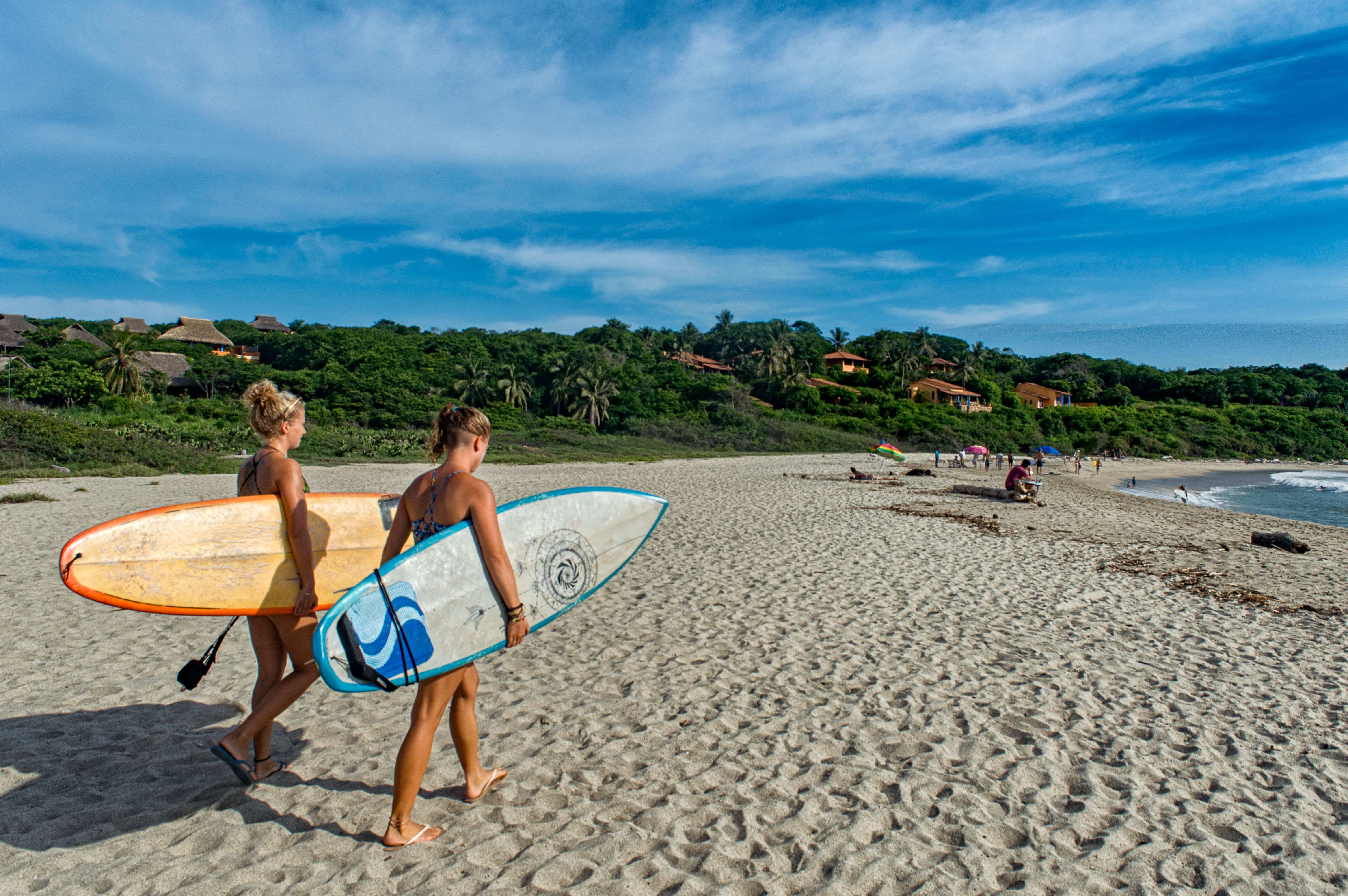 Are Puerto Escondido to Oaxaca Day Trip Tours Worth It – Surfers on a beach in Puerto Escondido.