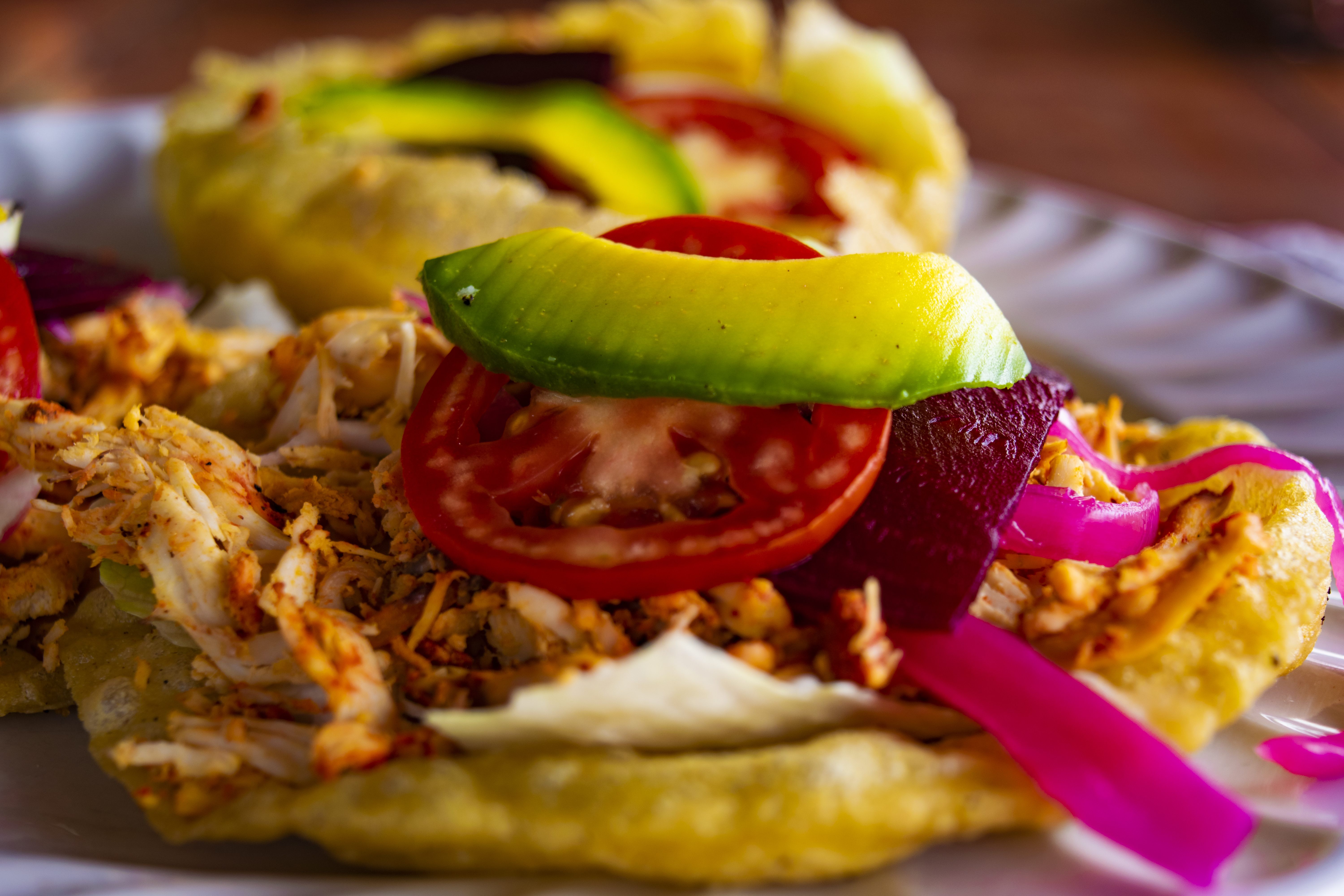 Best Valladolid Tours to Book in 2026 – Cochinita pibil served with avocado, tomato, and pickled onion in Yucatán.