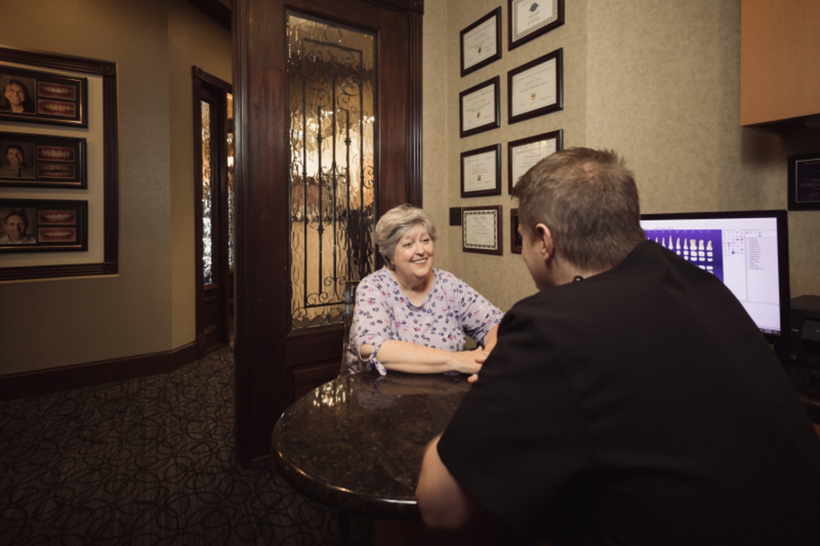 Dentist providing post-treatment care instructions to patient in treatment room