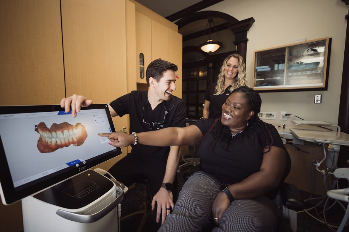 Dentist showing patient digital dental imaging on computer screen during consultation